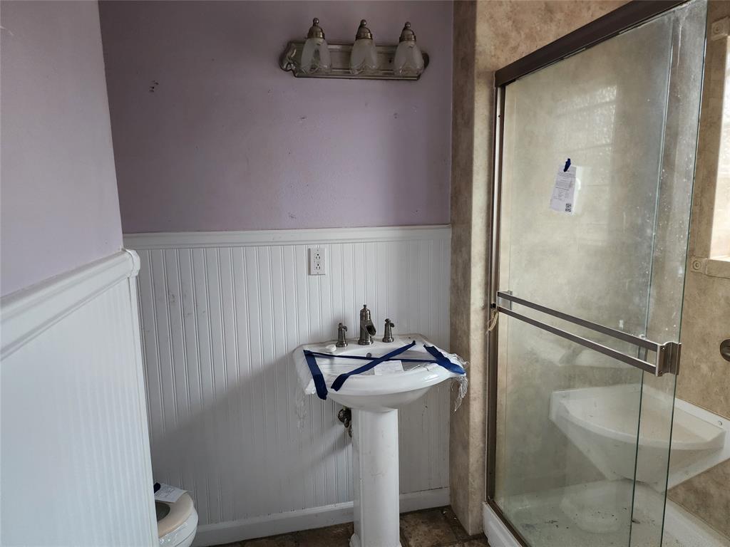 407 Largent Avenue Ballinger, TX 76821 - Photo 13 of 17 Primary Bathroom featuring a wainscoted wall and a shower stall