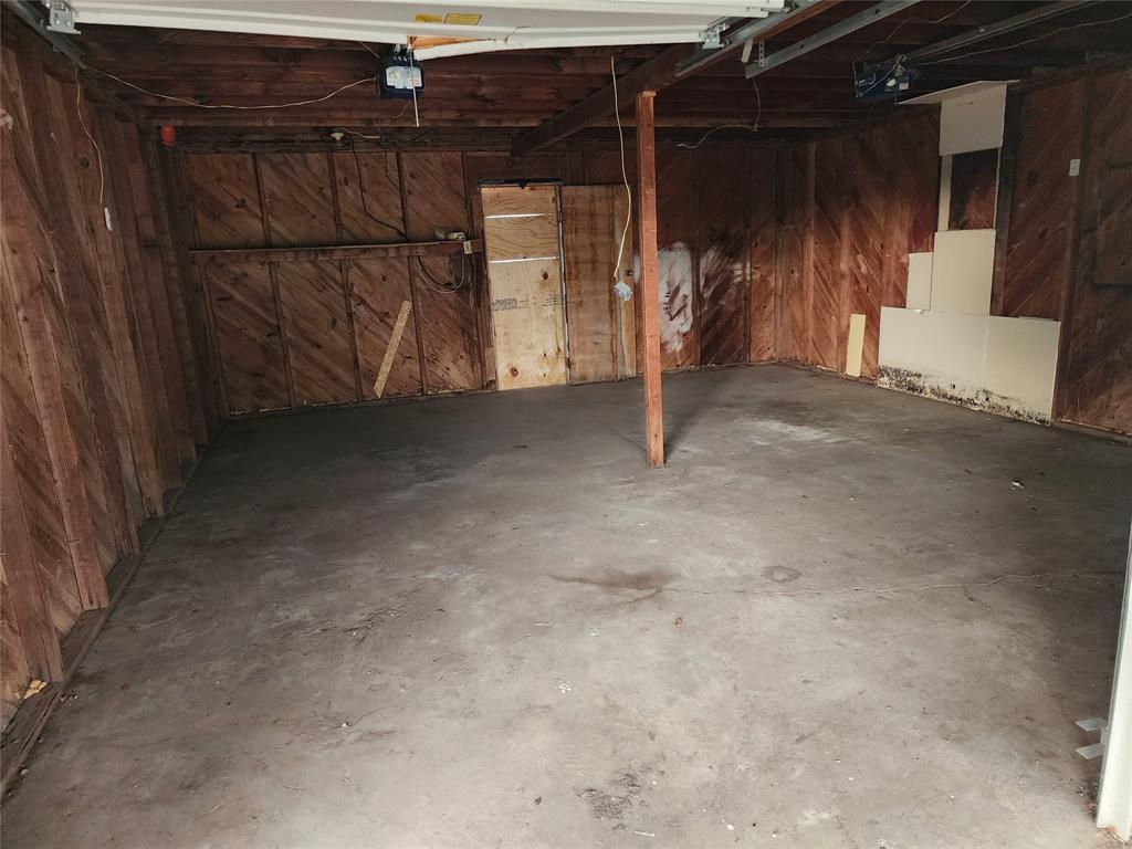 407 Largent Avenue Ballinger, TX 76821 - Photo 16 of 17 Garage featuring wooden walls and a garage door opener