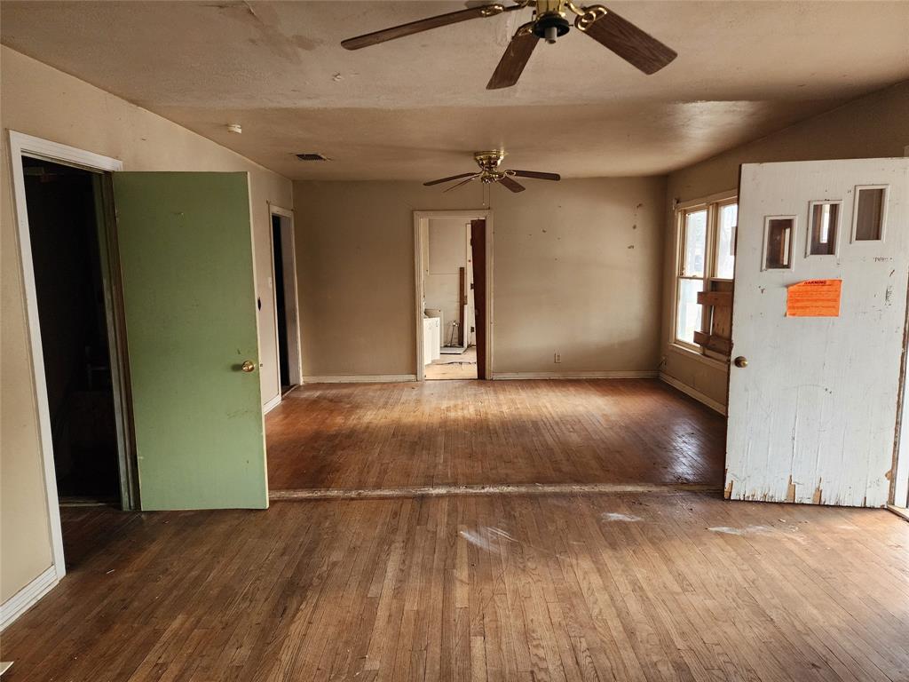 407 Largent Avenue Ballinger, TX 76821 - Photo 2 of 17 Unfurnished living room featuring hardwood / wood-style flooring and baseboards