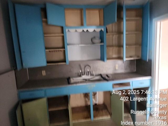 407 Largent Avenue Ballinger, TX 76821 - Photo 7 of 17 Kitchen featuring open shelves and blue cabinetry - Left Side