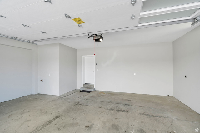 7045 South 300 East Midvale, UT 84047 - Photo 36 of 49 Spacious garage featuring a concrete floor, light gray walls, and an overhead garage door opener