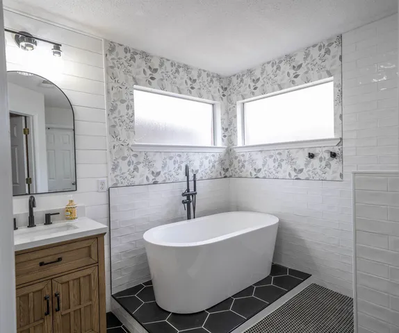 a bathroom with a sink mirror bathtub and window