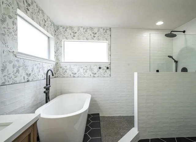 a bathroom with a double vanity sink mirror and bathtub