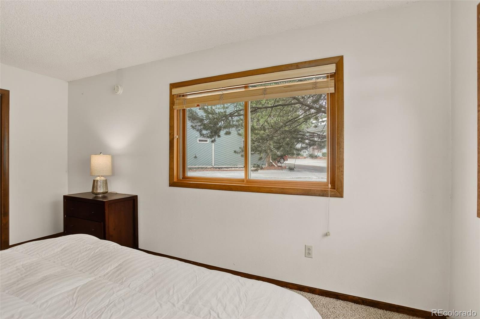 300 Sterling Way, Unit 2 Fraser, CO 80442 - Photo 19 of 28 a bedroom with a bed and a lamp next to a window