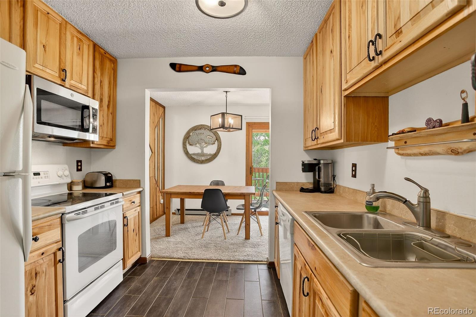 300 Sterling Way, Unit 2 Fraser, CO 80442 - Photo 7 of 28 a kitchen with stainless steel appliances granite countertop a sink and wooden cabinets