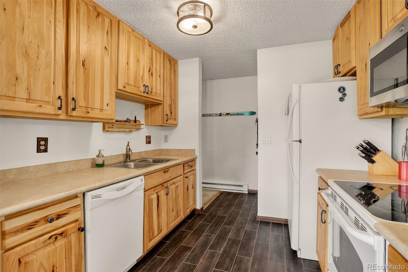 300 Sterling Way, Unit 2 Fraser, CO 80442 - Photo 9 of 28 a kitchen with a sink stove and cabinets