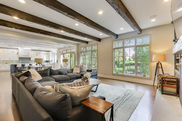 a kitchen with stainless steel appliances kitchen island granite countertop a stove a sink a refrigerator and white cabinets with wooden floor
