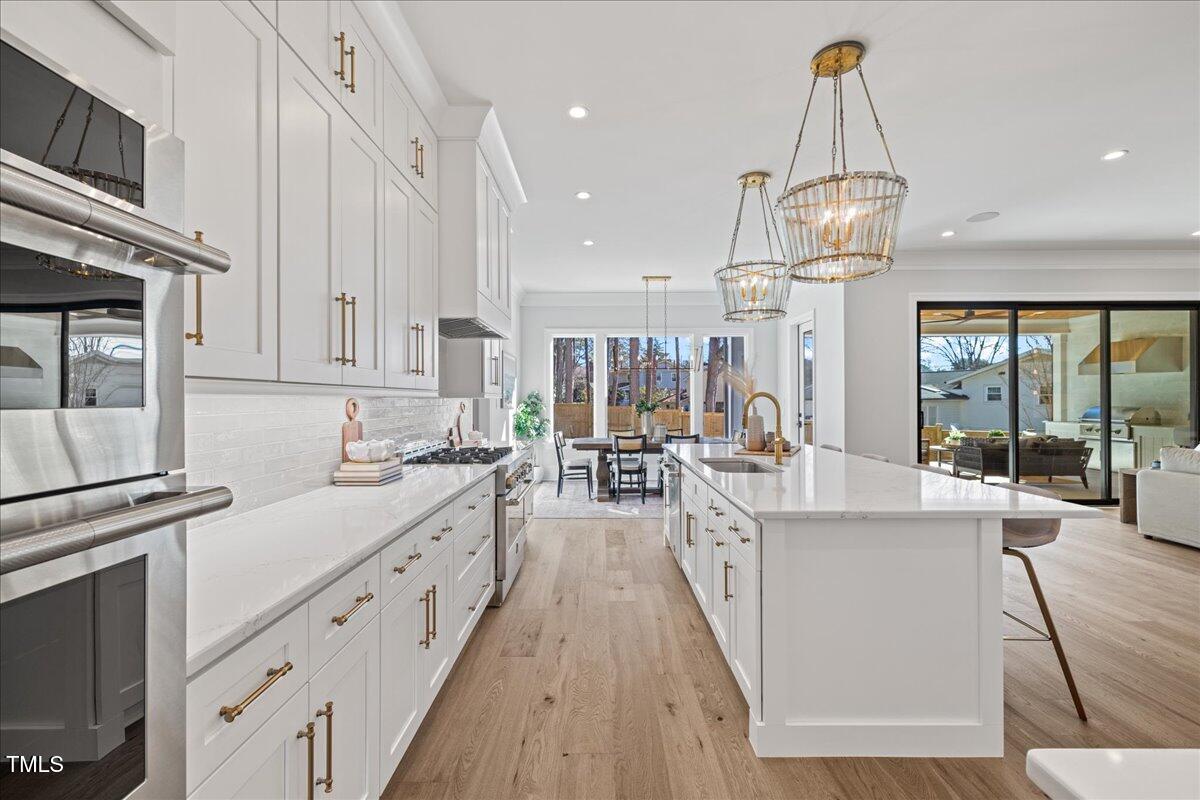 4906 Tremont Drive Raleigh, NC 27609 - Photo 12 of 78 a large kitchen with kitchen island lots of counter space wooden floor and stainless steel appliances