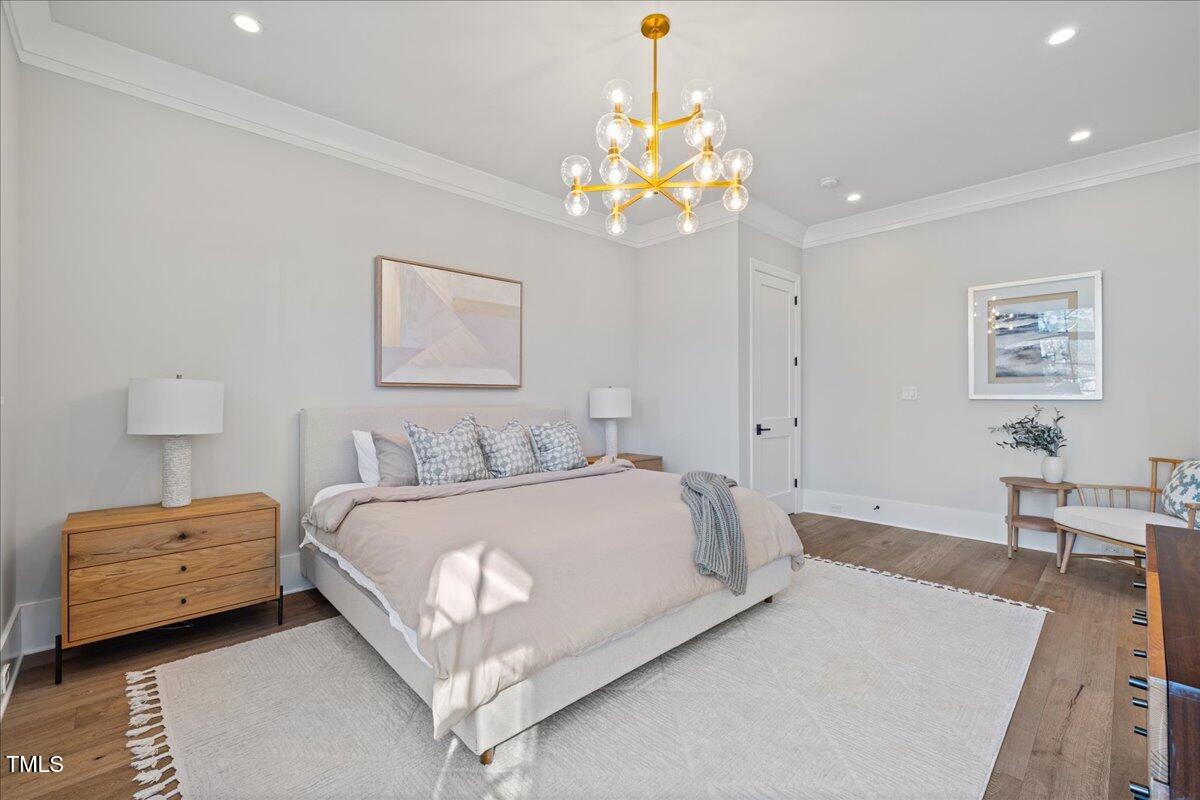4906 Tremont Drive Raleigh, NC 27609 - Photo 25 of 78 a bedroom with a bed chandelier and a window