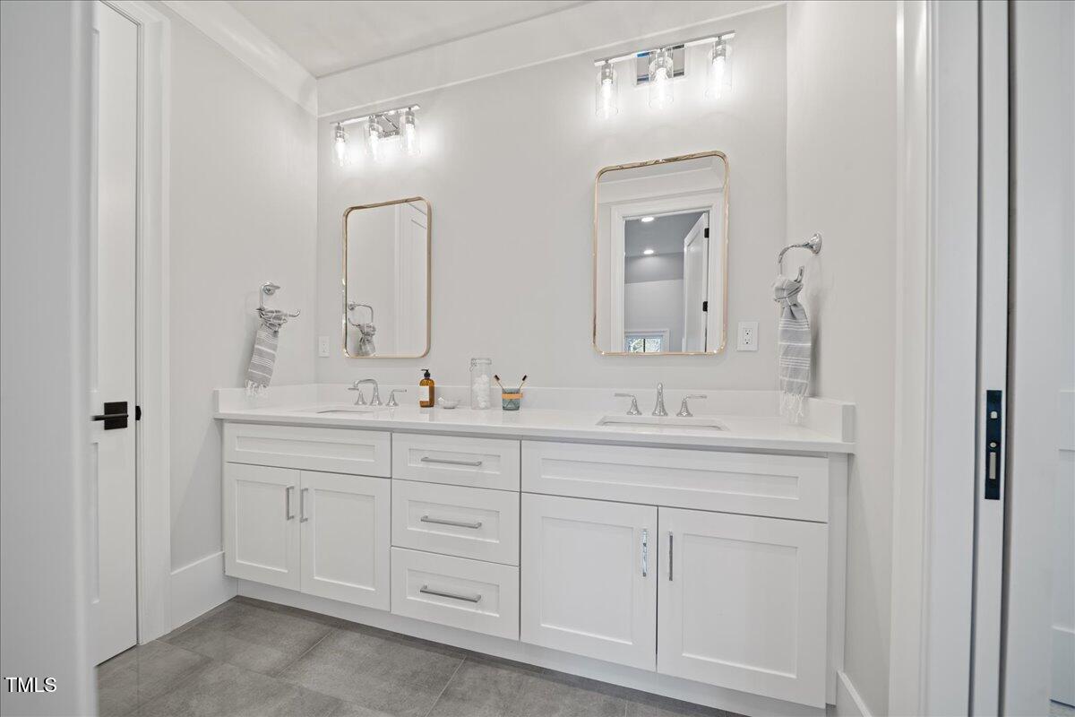 4906 Tremont Drive Raleigh, NC 27609 - Photo 55 of 78 a bathroom with a double vanity sink and a mirror