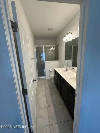 a bathroom with a double vanity sink and mirror