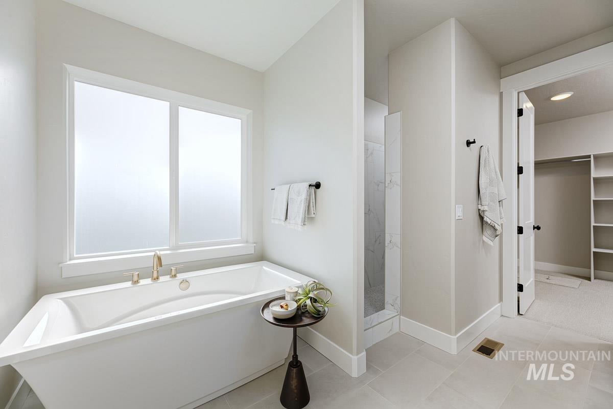 6792 Saddle Bred Way Star, ID 83669 - Photo 13 of 33 Bathroom featuring a soaking tub, a walk in shower, and a spacious closet