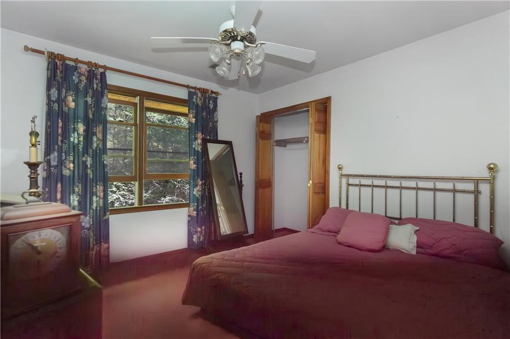 80 Riverbend Circle Ellijay, GA 30536 - Photo 19 of 32 a bedroom with a large bed and a chandelier