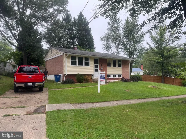 a front view of a house with a garden and trees