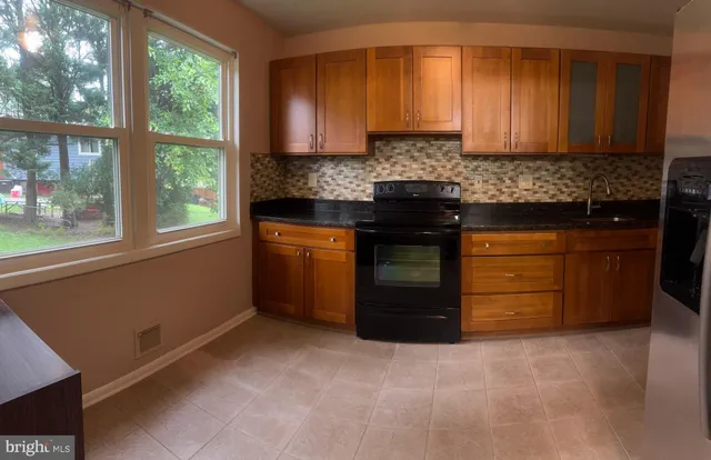 a kitchen with stainless steel appliances granite countertop a stove a sink and a white cabinets