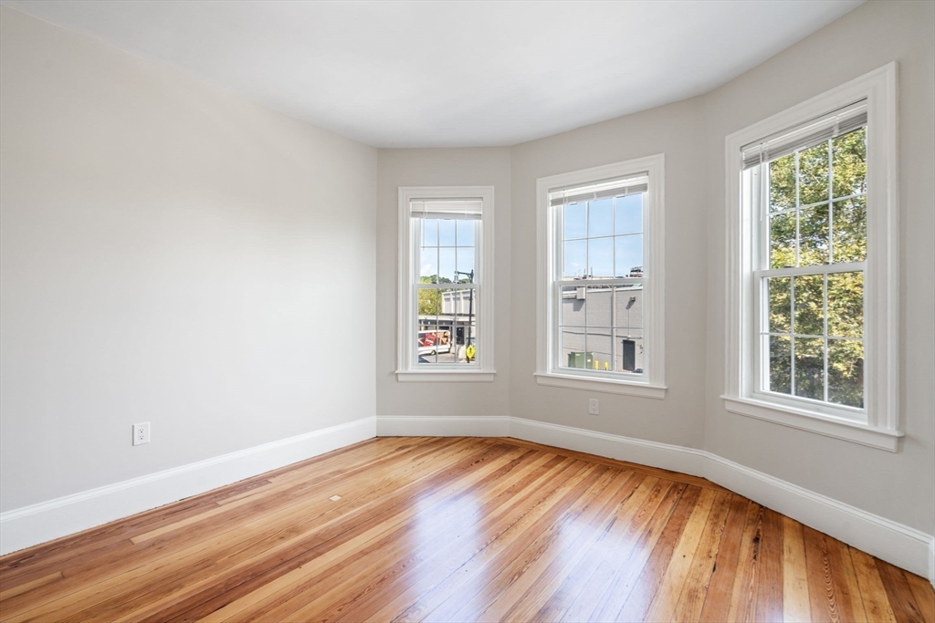 511 Geneva Avenue, Unit 2 Boston, MA 02122 - Photo 11 of 16 an empty room with wooden floor and windows