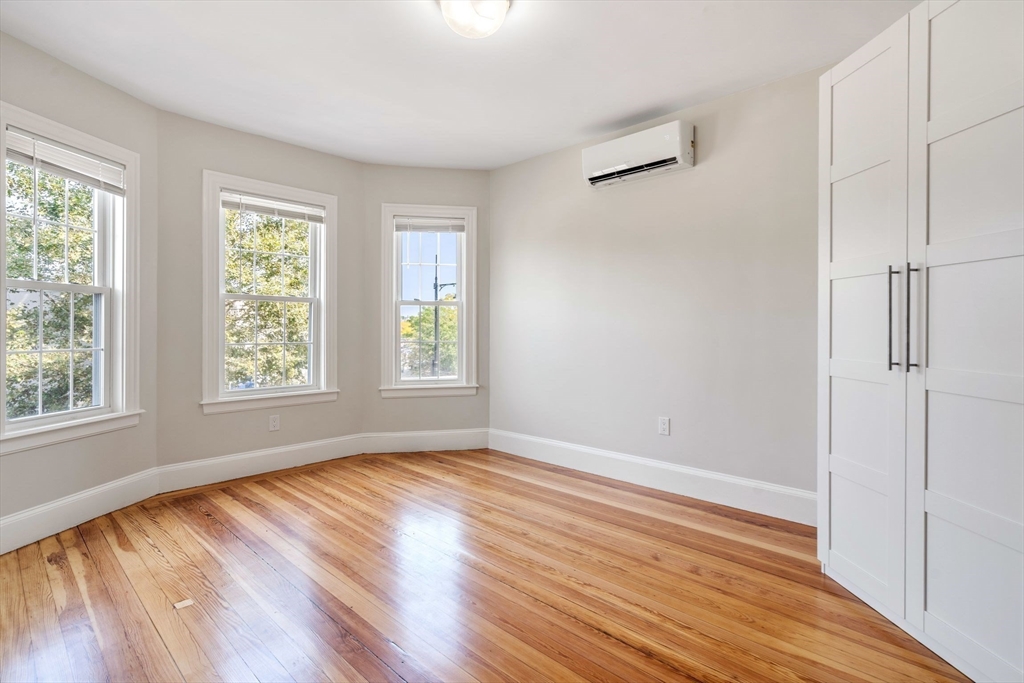 511 Geneva Avenue, Unit 2 Boston, MA 02122 - Photo 12 of 16 a view of an empty room with wooden floor and a window