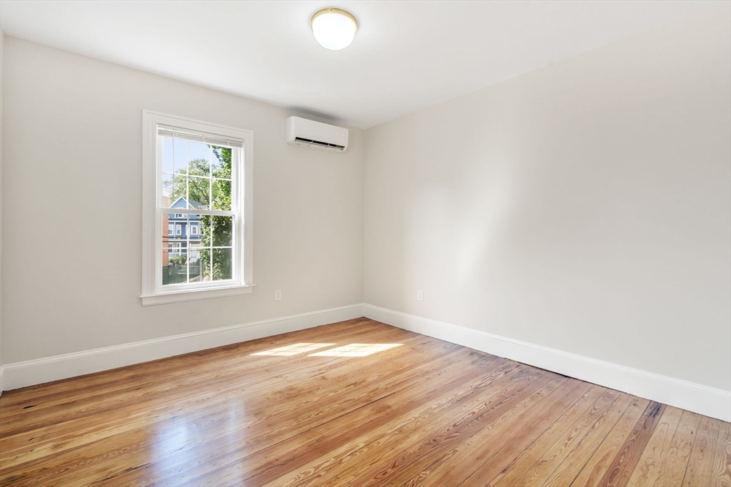 511 Geneva Avenue, Unit 2 Boston, MA 02122 - Photo 4 of 16 an empty room with wooden floor and windows