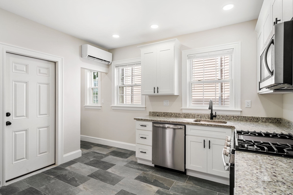 511 Geneva Avenue, Unit 2 Boston, MA 02122 - Photo 5 of 16 a kitchen with a stove a sink and a window