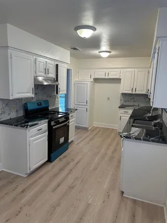 a kitchen with granite countertop a stove and a sink