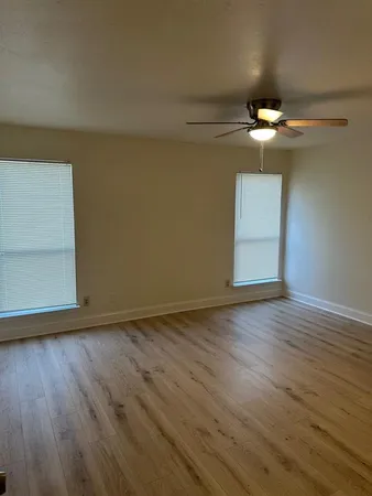 a view of empty room with wooden floor