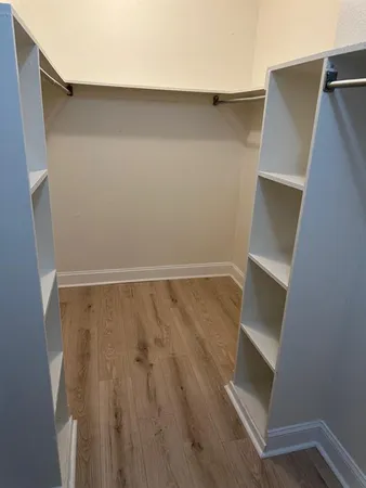 a view of walk in closet with wooden floor
