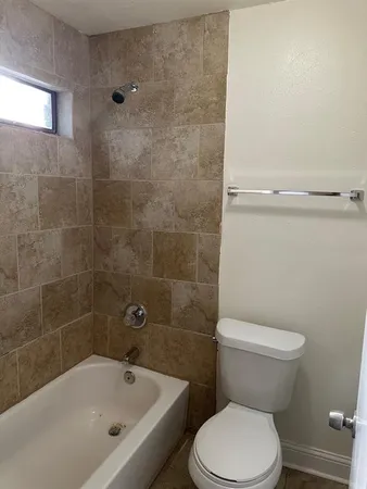a white toilet sitting next to a bath tub
