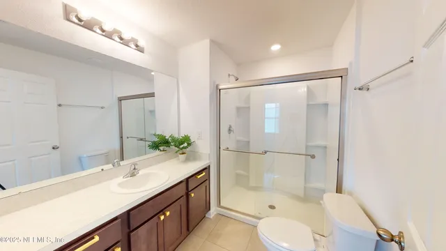 a bathroom with a shower sink vanity mirror and toilet