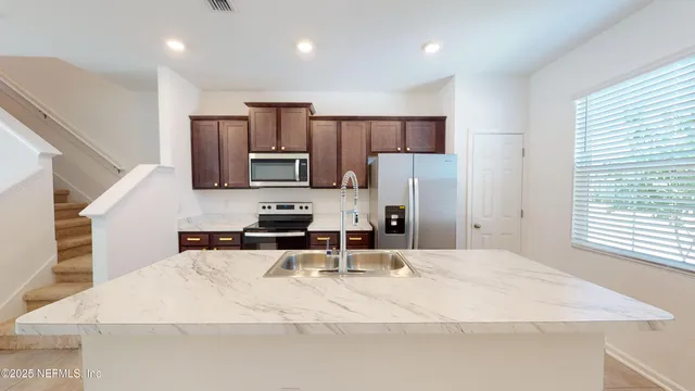 a kitchen with stainless steel appliances a sink stove and refrigerator