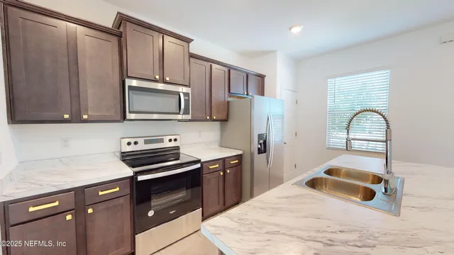 a kitchen with granite countertop a stove a sink and a microwave