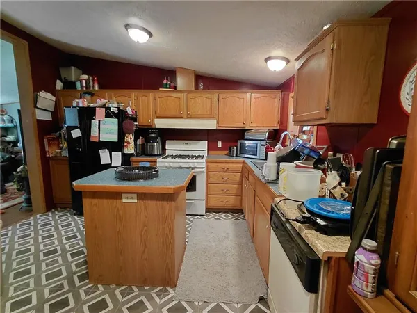 a kitchen with stainless steel appliances granite countertop a stove top oven a sink and cabinets