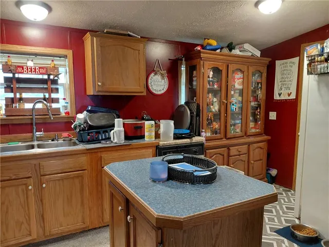 a kitchen with stainless steel appliances granite countertop a sink dishwasher and a stove with wooden floor