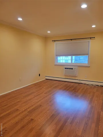 an empty room with wooden floor and a window