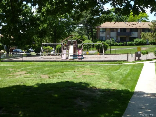a view of a swimming pool with lawn chairs and a big yard
