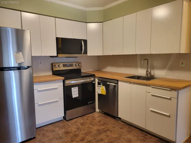 a kitchen with stainless steel appliances a refrigerator stove and microwave