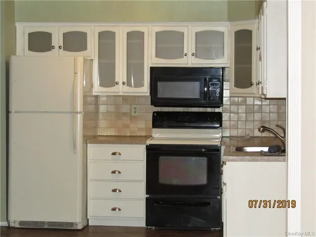 a kitchen with stainless steel appliances granite countertop a stove a microwave and a refrigerator