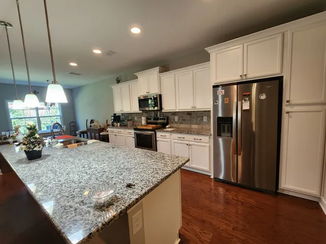 a kitchen with stainless steel appliances granite countertop a sink refrigerator and microwave