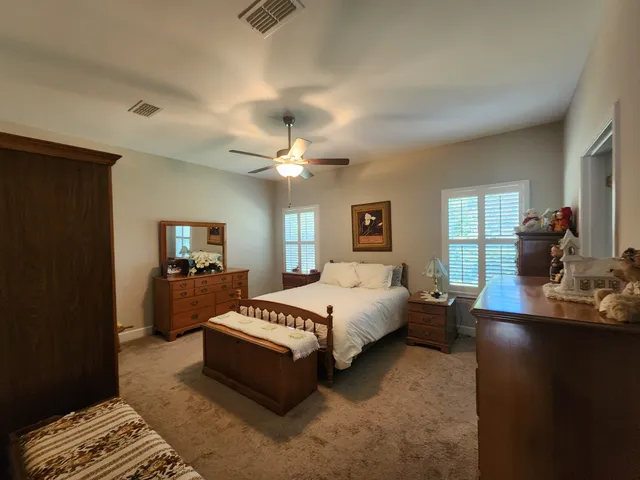 a spacious bedroom with a bed and a chandelier