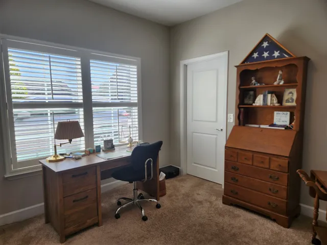 a view of a workspace with furniture and a window