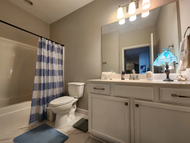a bathroom with a sink toilet a mirror and shower