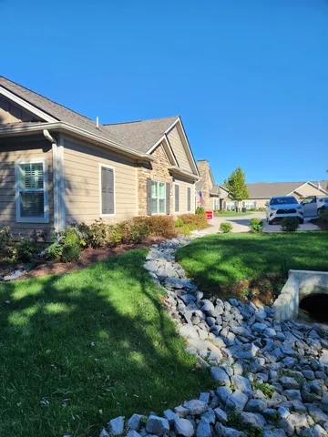a backyard of a house with plants and wooden fence