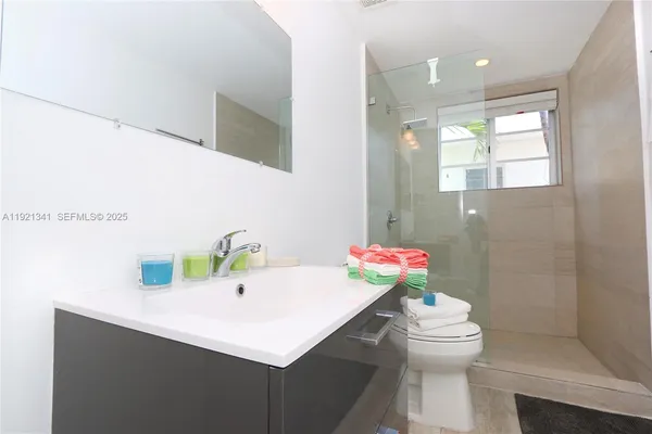 a bathroom with a sink a toilet and mirror