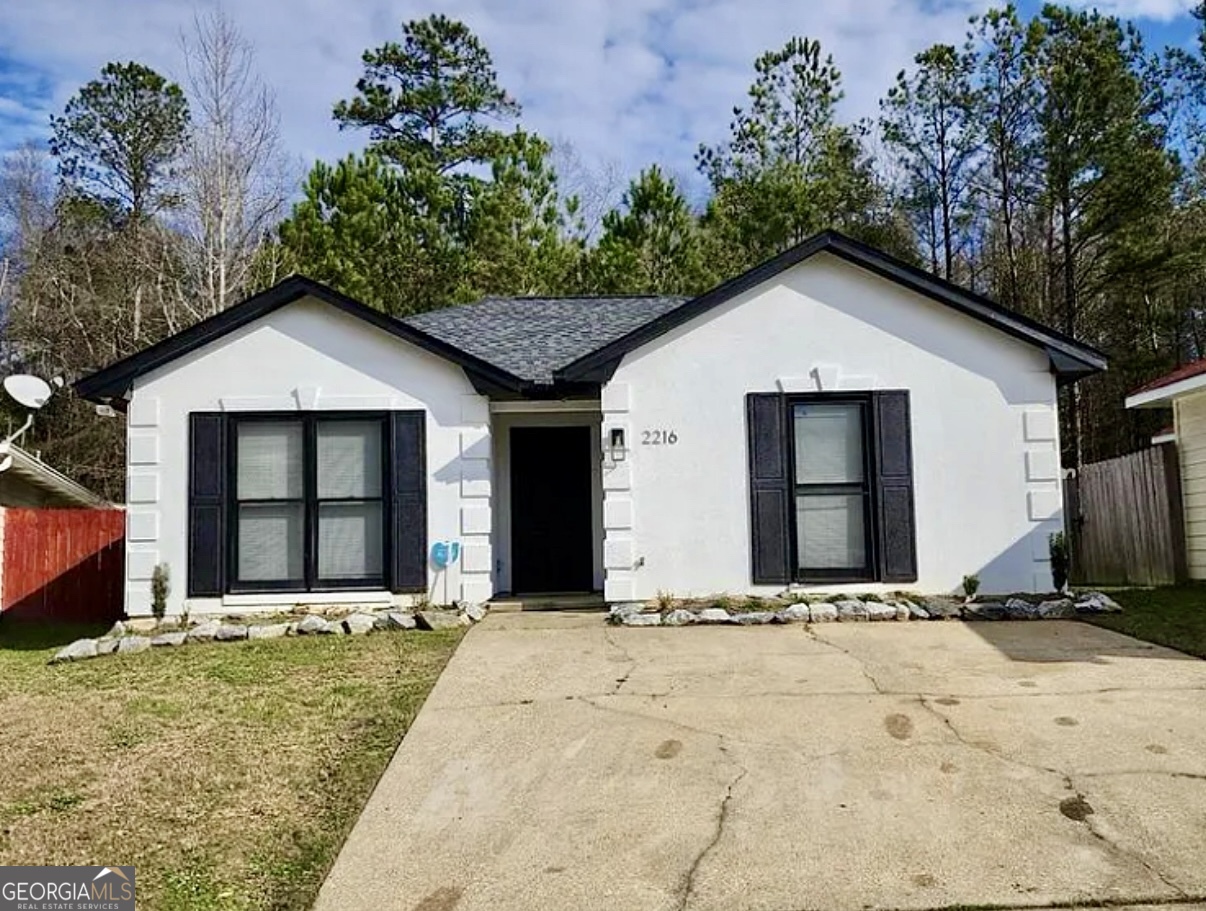 a front view of a house with a yard and trees