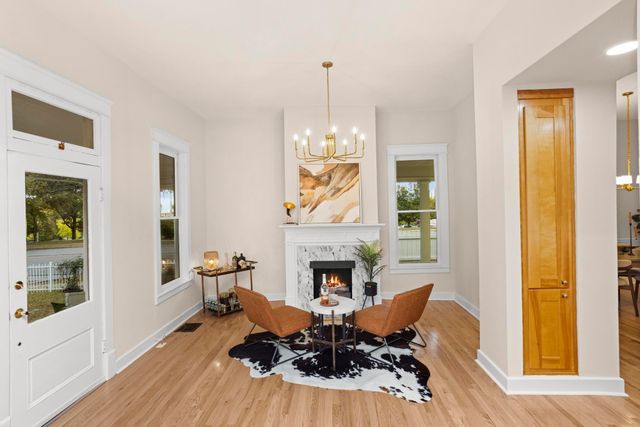 a living room with furniture a fireplace and a chandelier
