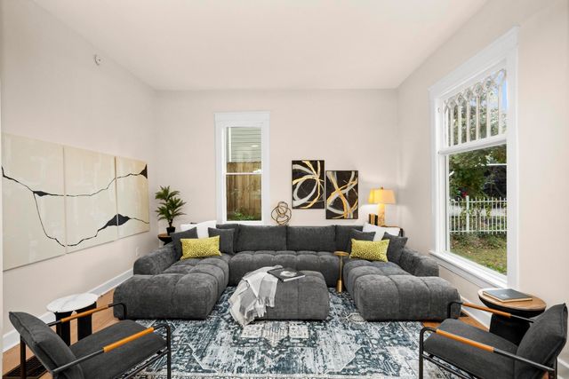 a living room with furniture and a floor to ceiling window