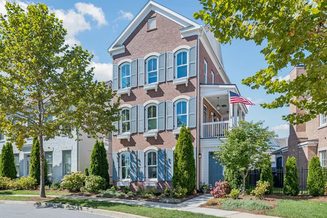 a front view of a residential houses with yard and green space