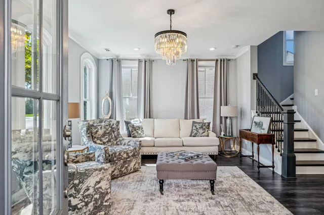 a living room with furniture a rug and a chandelier