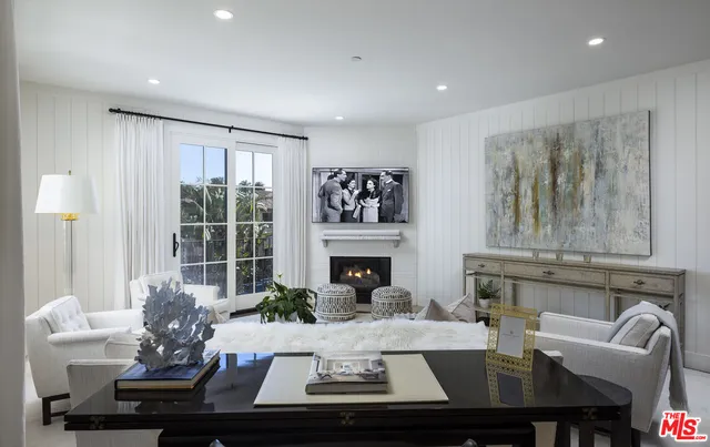a living room with fireplace furniture and a large window