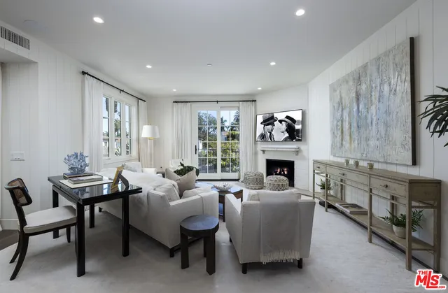 a dining room with furniture a wooden floor and kitchen view