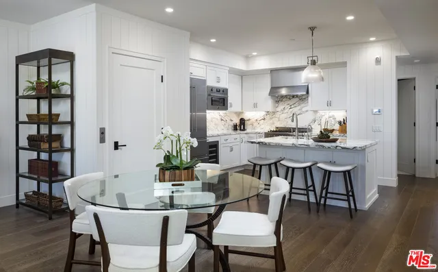 a kitchen with kitchen island granite countertop a sink cabinets and refrigerator